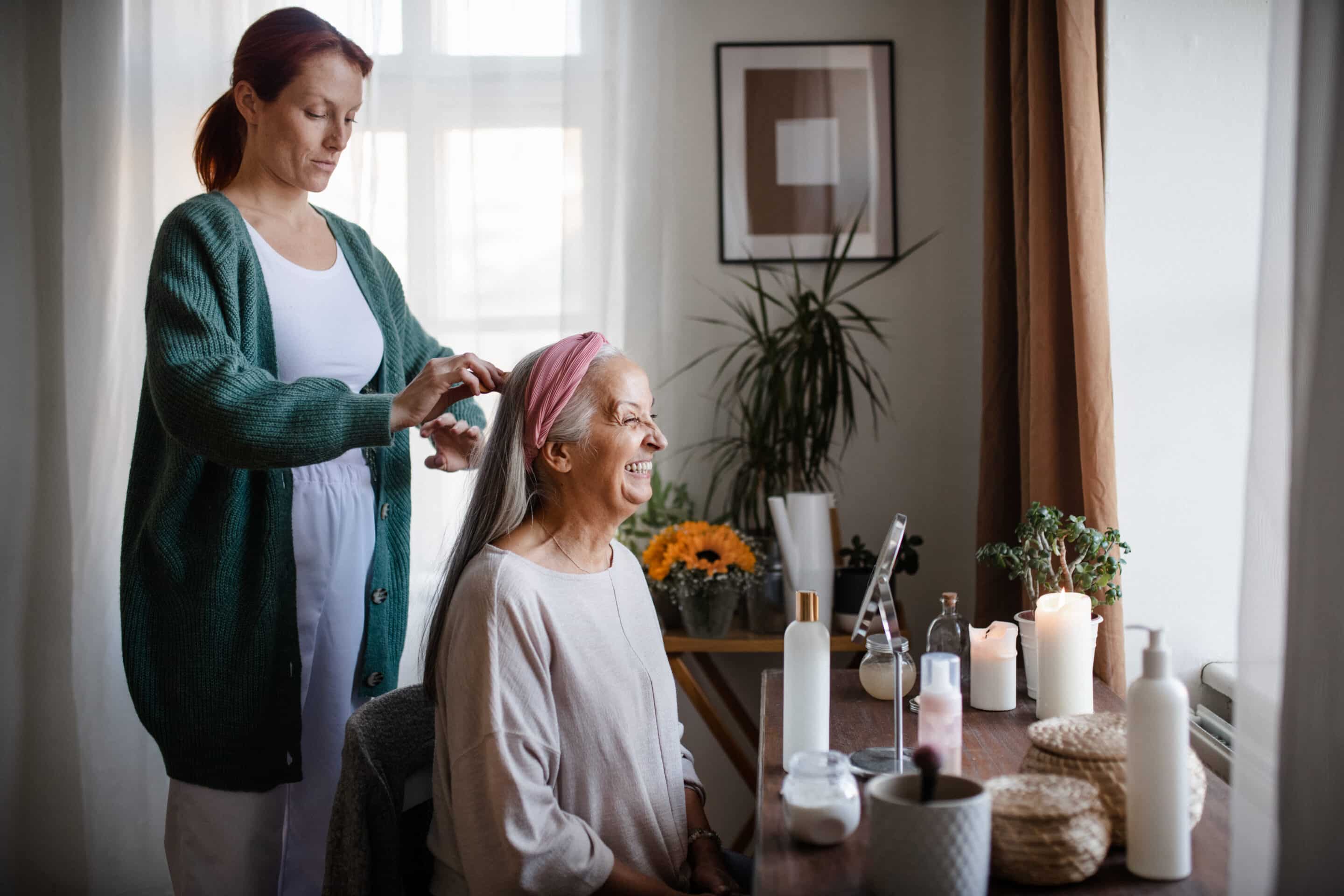 Caregiver helping her client with a hairstyle.
