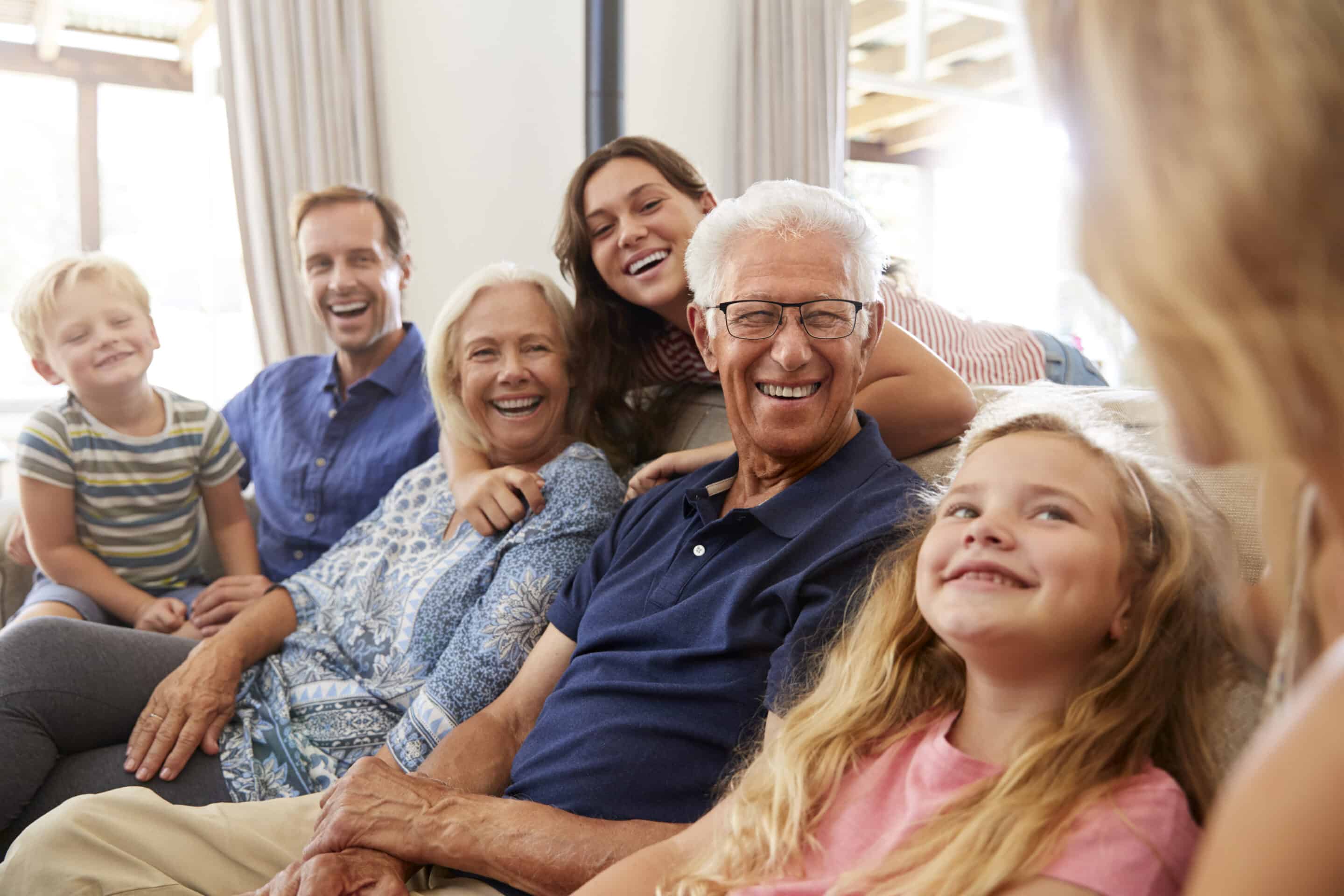 Multi-Generation Family Sitting On Sofa At Home in the living room